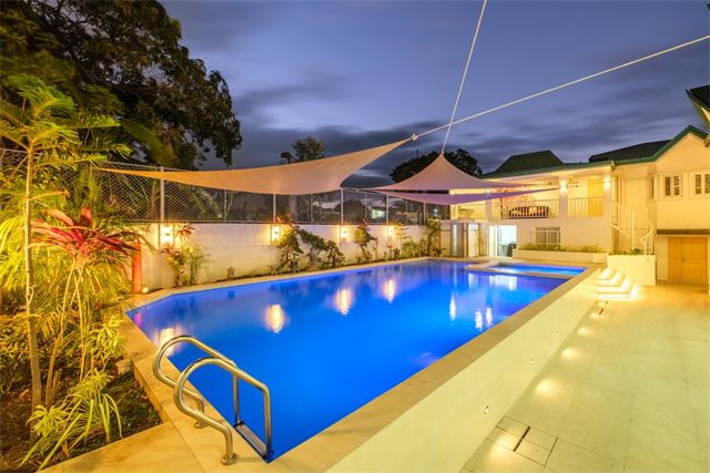 Pool and garden lit up at dusk