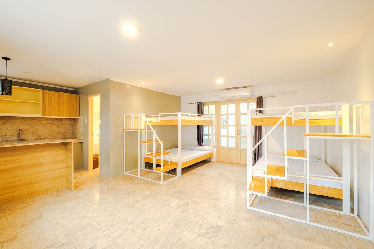 Bright bedroom with white bunk beds and wooden cabinets