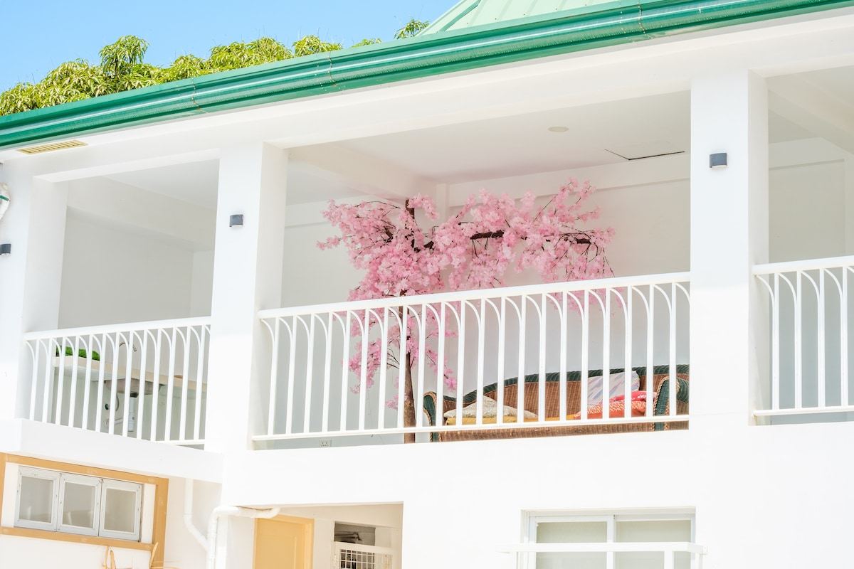 White balcony with a pink cherry blossom tree