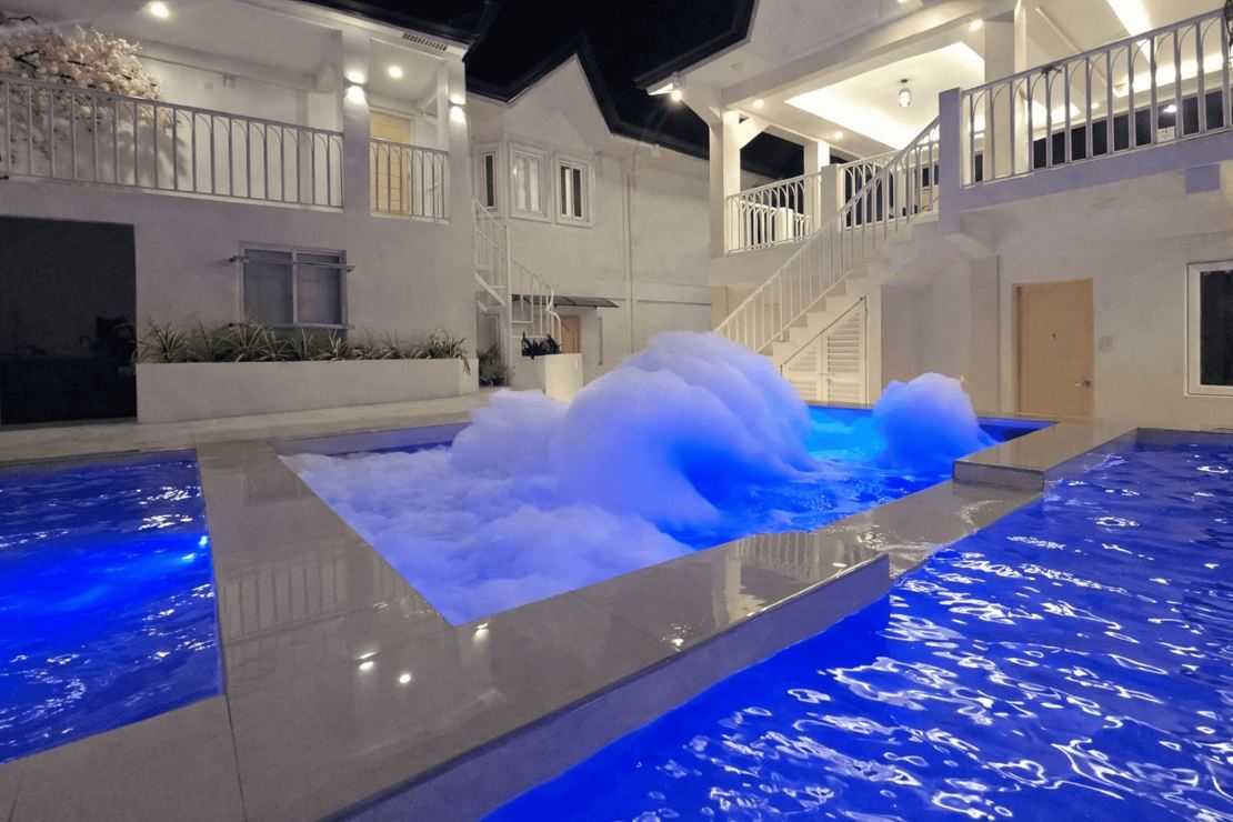 Jacuzzi with bubbling jets beside the large pool at night